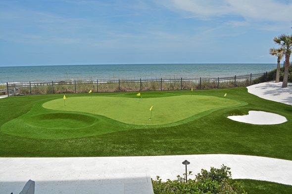Fresno Synthetic grass golf green by the sea with yellow flags and a sand bunker