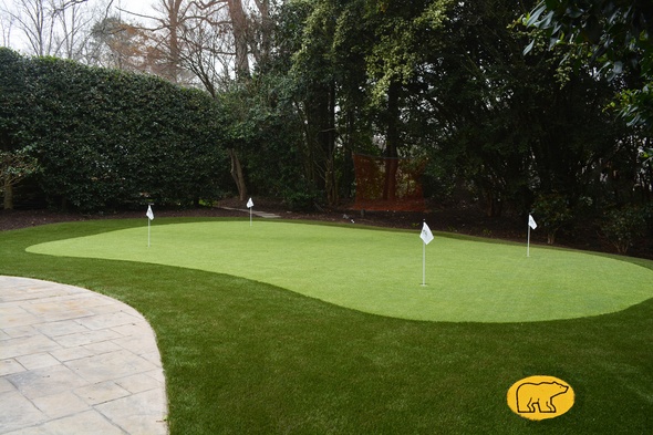 Fresno Synthetic grass golf green with 4 holes and flags in a landscaped backyard