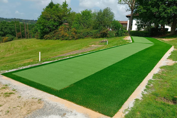 Fresno Outdoor tee line consisting of one continuous green synthetic grass strip surrounded by trees